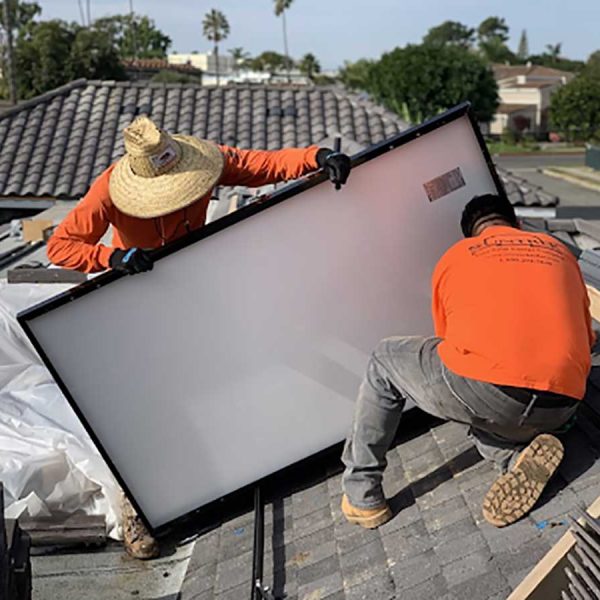 Two technicians repairing a solar water heater panel on a roof, ensuring proper functionality of the system for water heating.